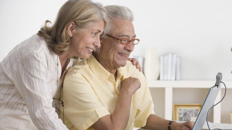 Senior Couple Using Webcam on Laptop