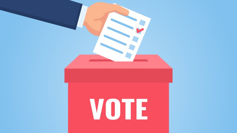 Hand puts vote bulletin into vote box. Election concept
