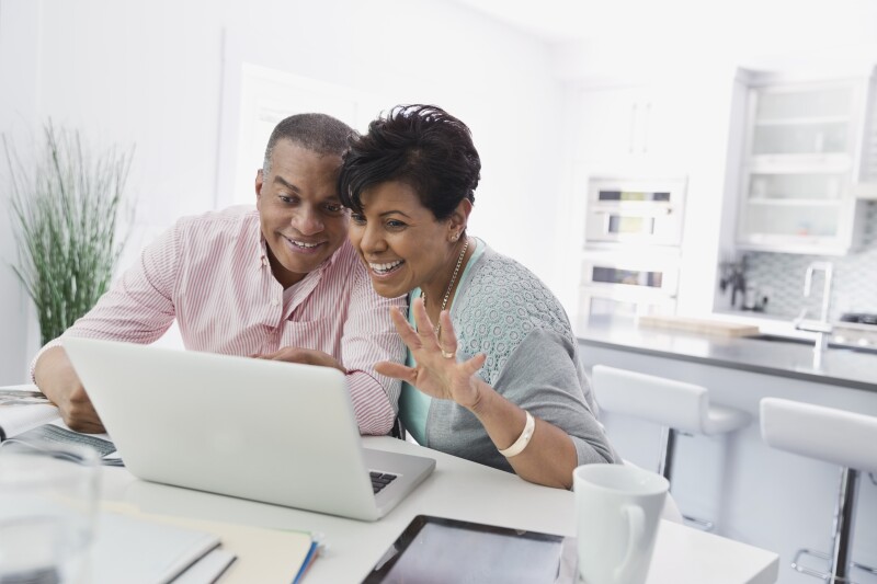Husband and wife enjoying a video chat on laptop