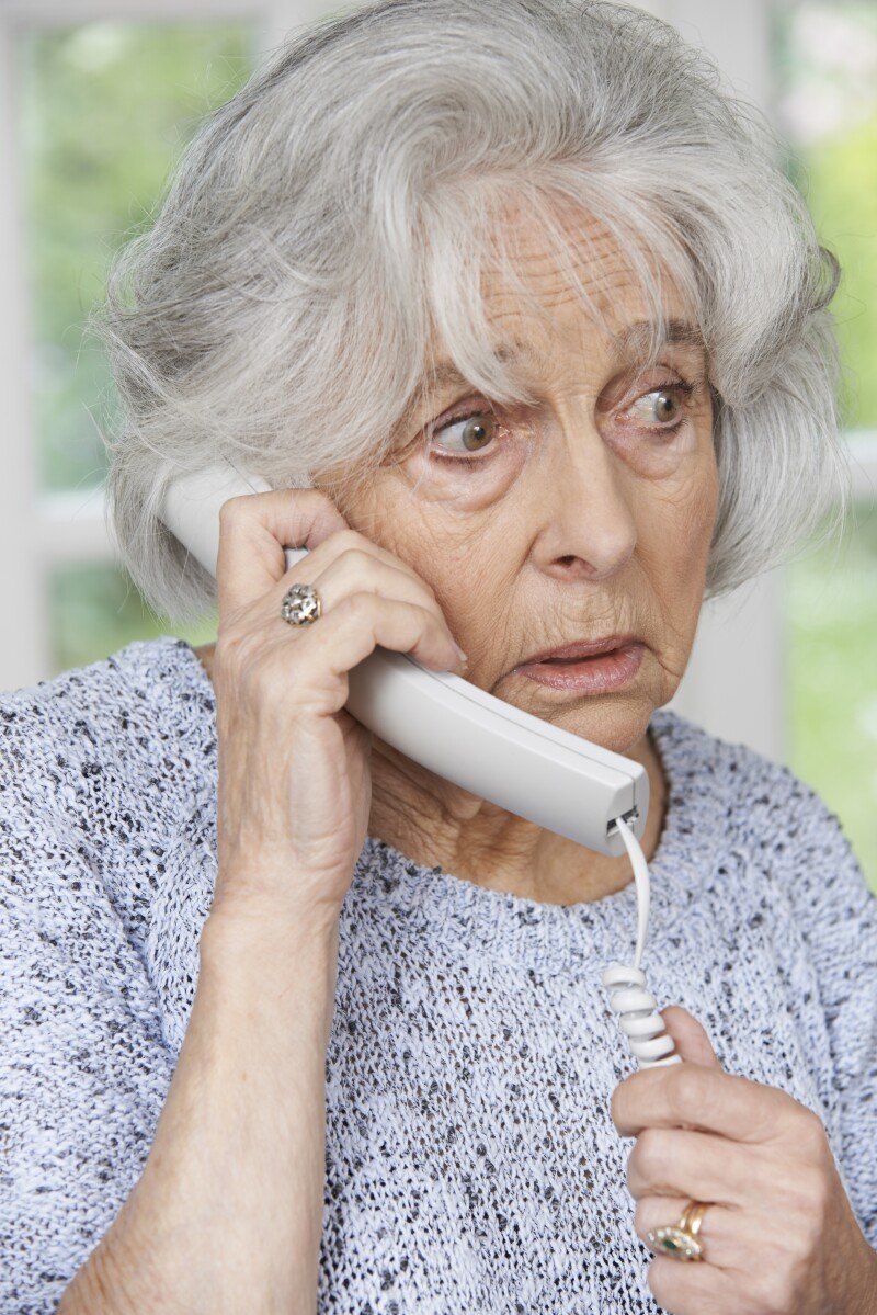Worried Senior Woman Answering Telephone At Home