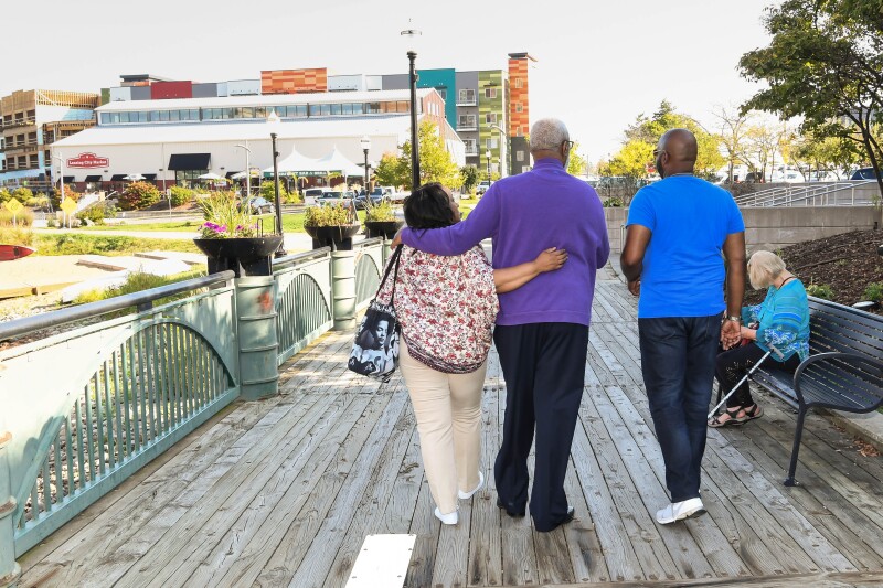 A group of people walk along the water in Lansing, Michigan.