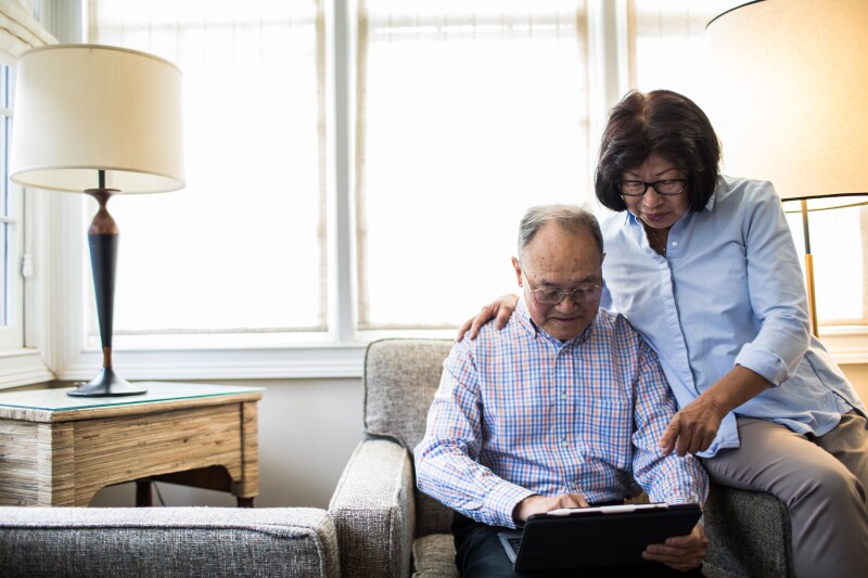 Senior couple at home using tablet