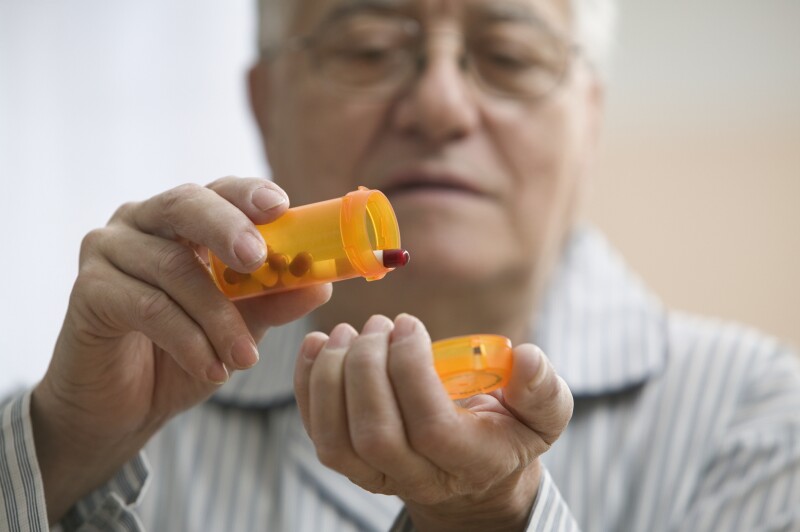 Older man shaking out pills into his hand