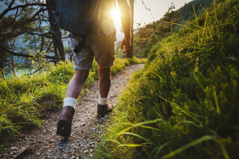Senior man trail hiking in a mountain forest