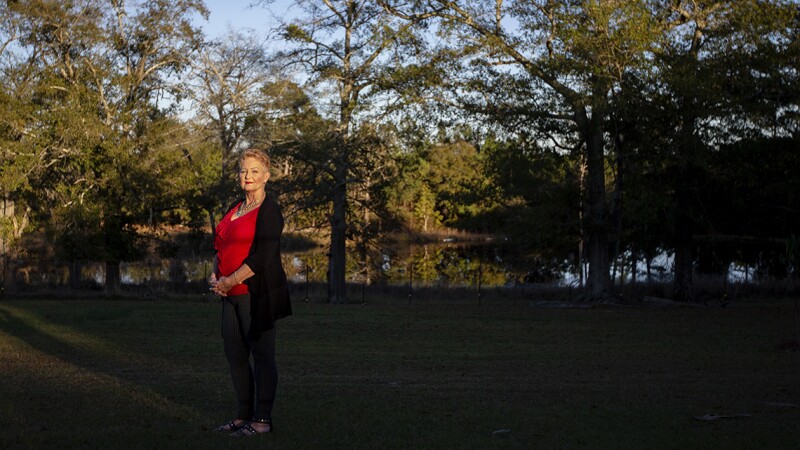 A woman stands in her backyard