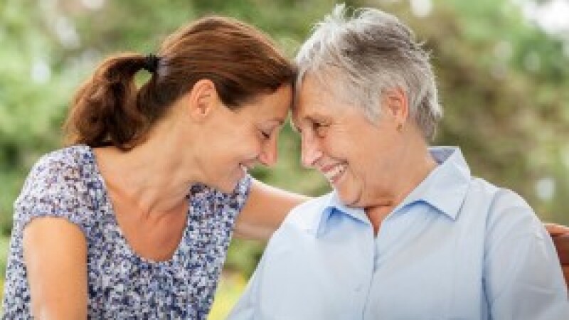mother and daughter smile, face each other. family caregiving