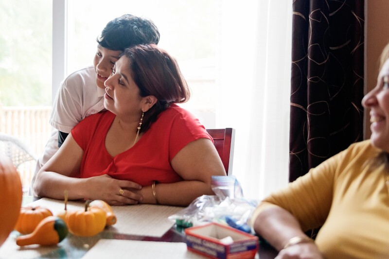 Tender moment for Latin American family carving pumpkins for Halloween