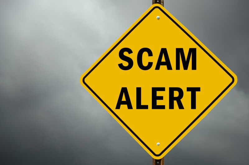 Scam alert conceptual traffic sign and stormy sky