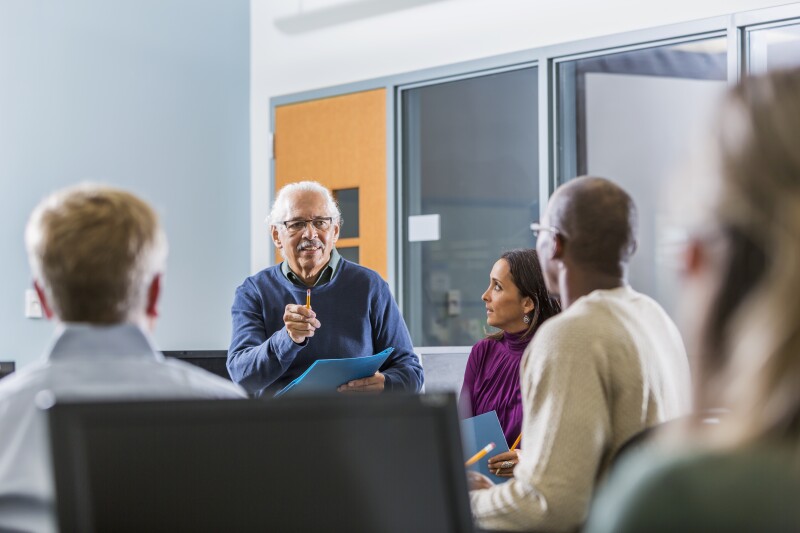 Senior Hispanic man teaching adult students