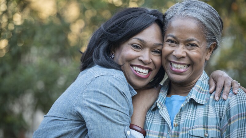 Mother and daughter hugging outdoors