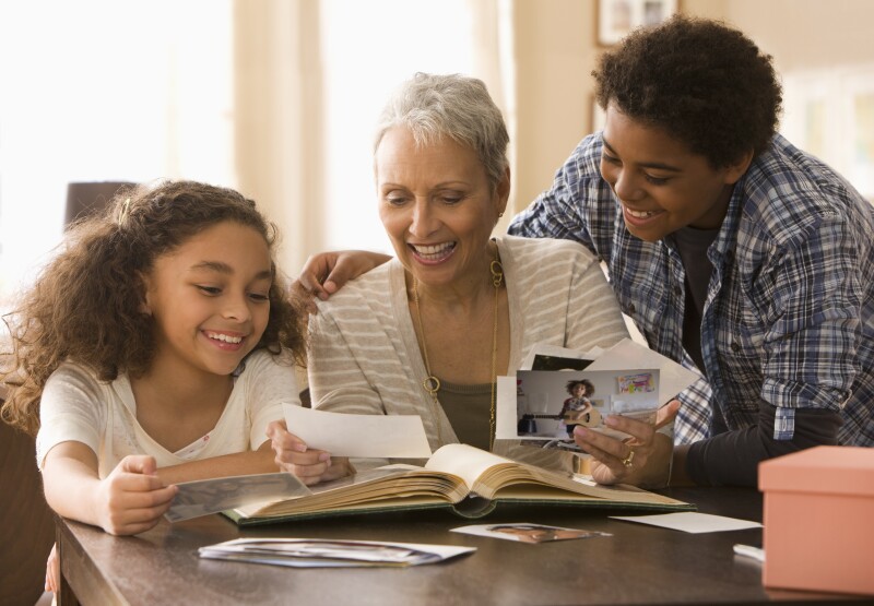 Grandmother and grandchildren looking at photographs