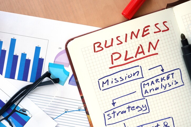 Notepad with words business plan concept and glasses.