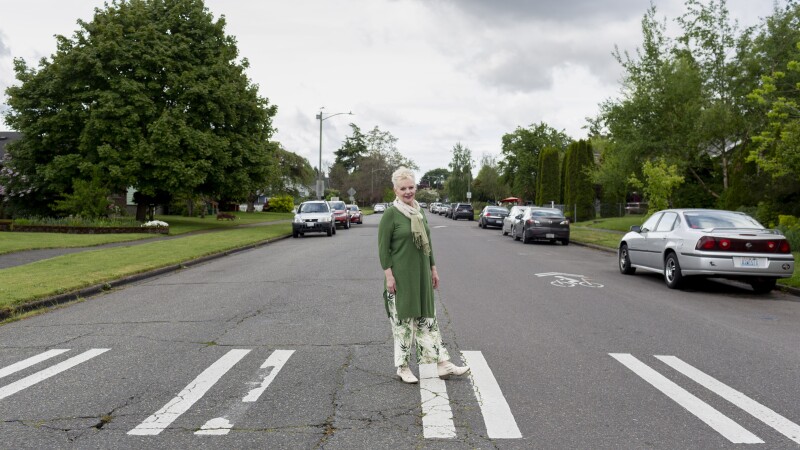 An older woman stands in a crosswalk
