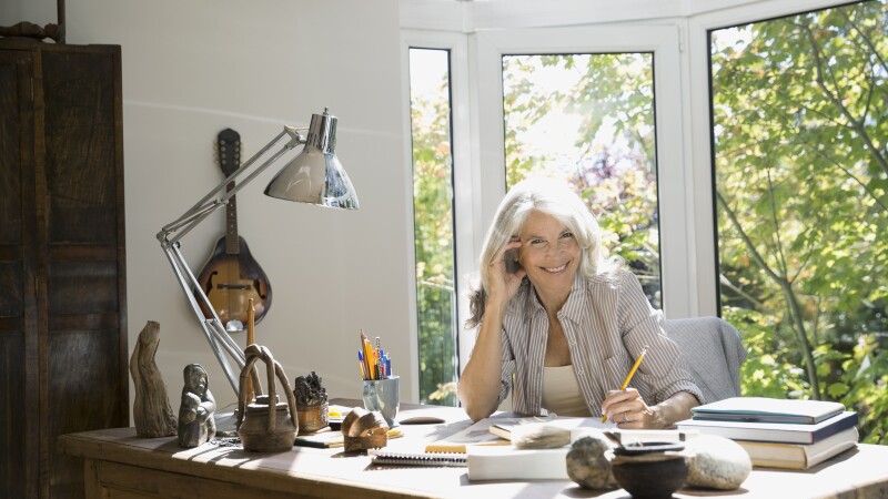 Portrait of senior woman writing in home office