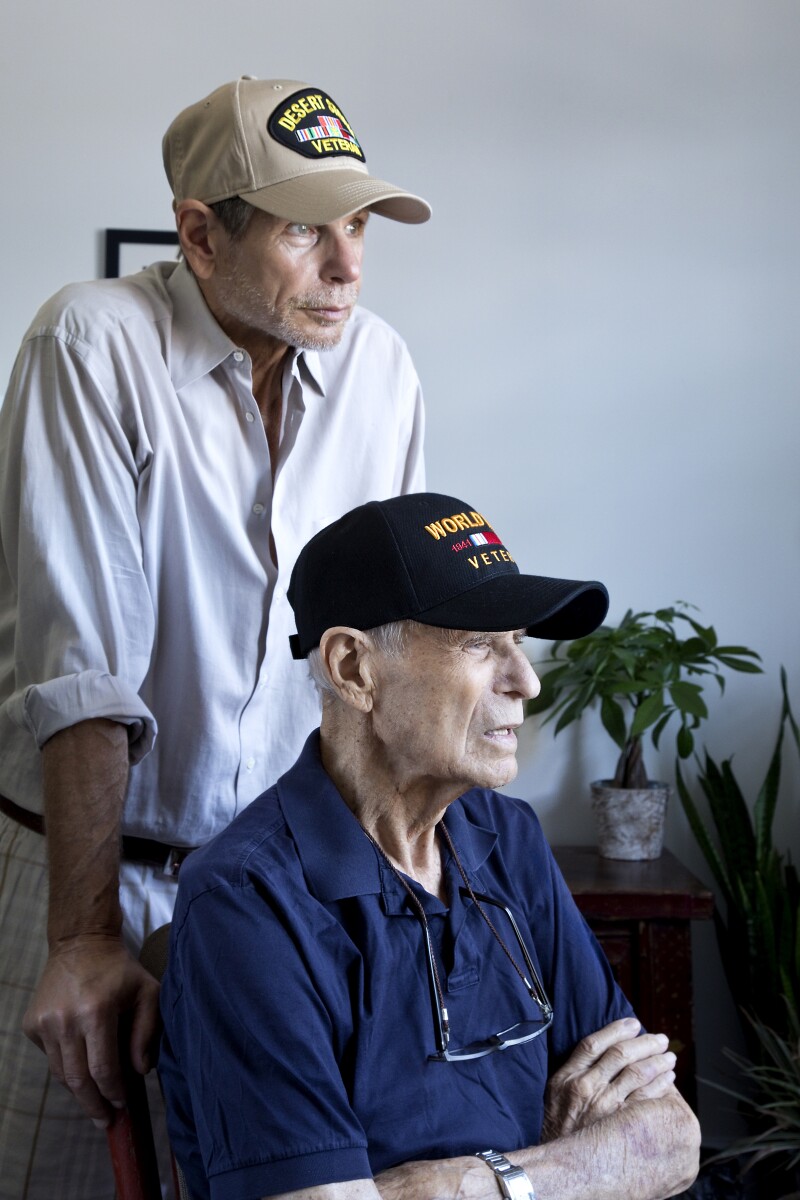 World War Two Veteran and son Gulf War Veteran at home looking toward window