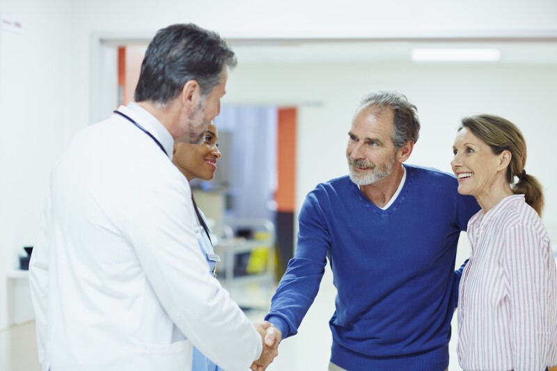 Doctor greeting couple in hospital