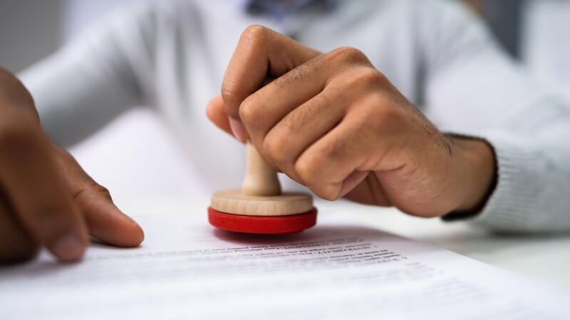 Person Hands Using Stamper On Document