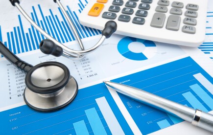 Stethoscope with financial statement, calculator, pen