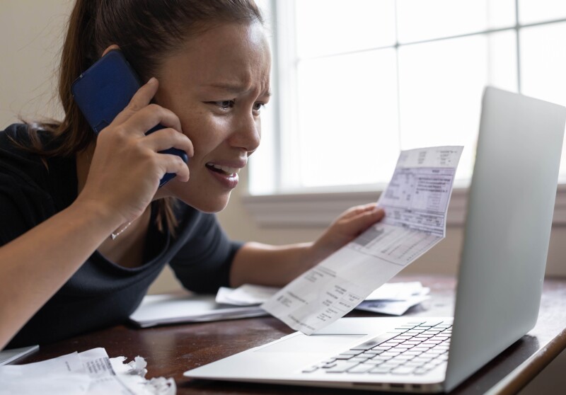 Stressed out broke woman checking her bills online. No money.