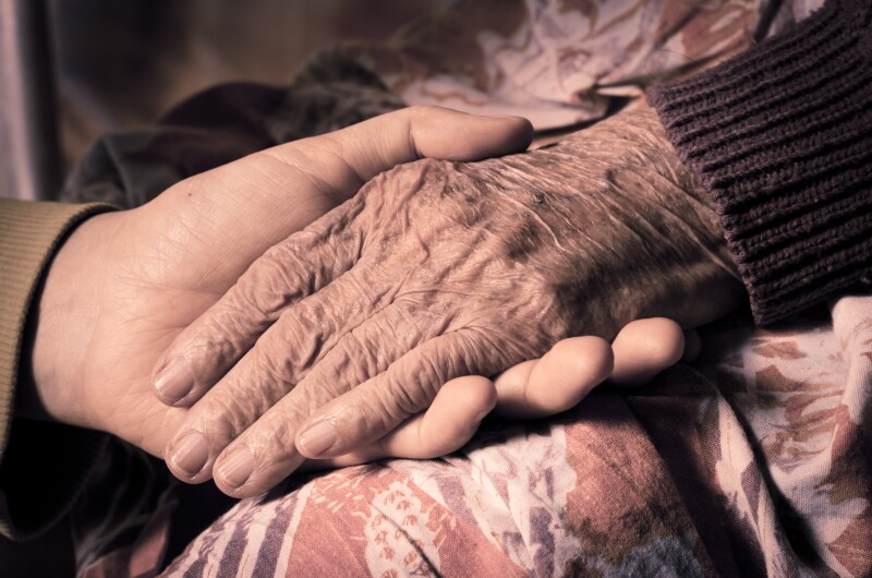 girl's hand holds an old woman's hands