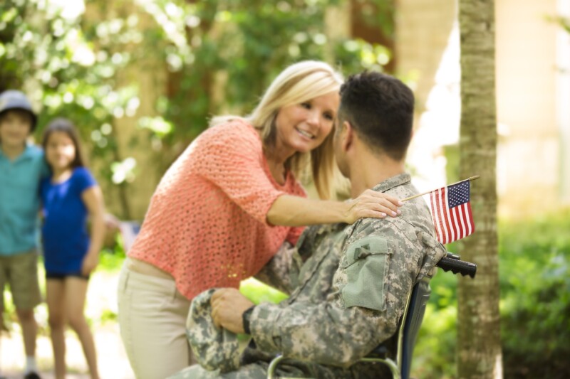 American military veteran welcomed home by family. Wheelchair, disabled. Home.
