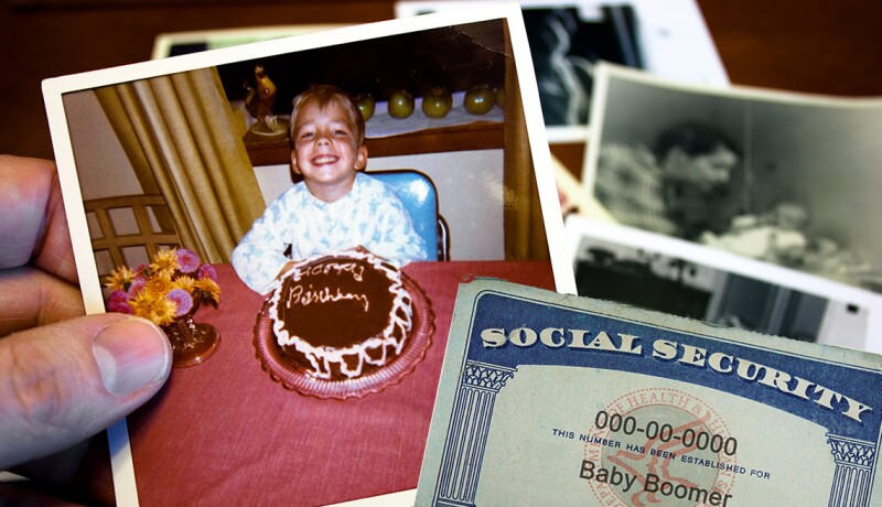 hand holds vintage photograph of a birthday boy with pile of old