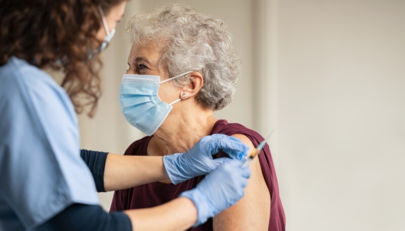 Doctor giving Covid vaccine to senior woman