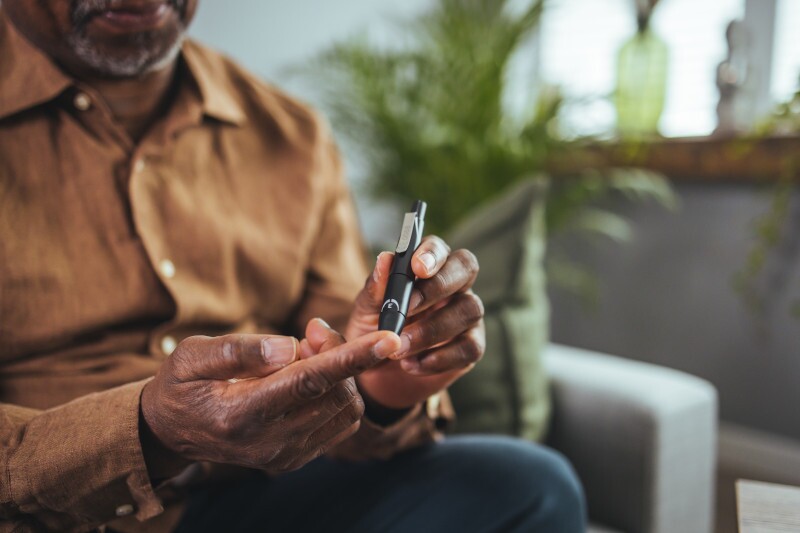 Everyday life of a man of African American nationality with a chronic disease who uses a glucose tester.