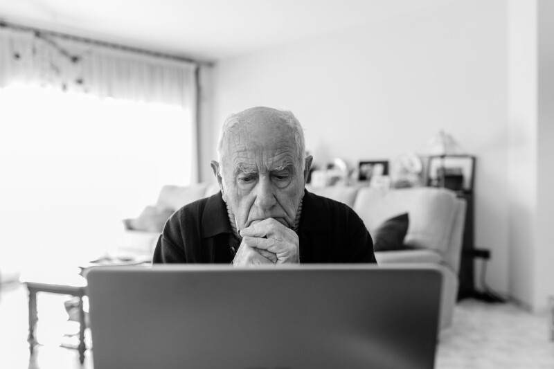 Portrait of senior man using laptop at home