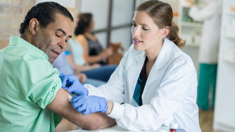Caring healthcare professional places bandage on man's arm