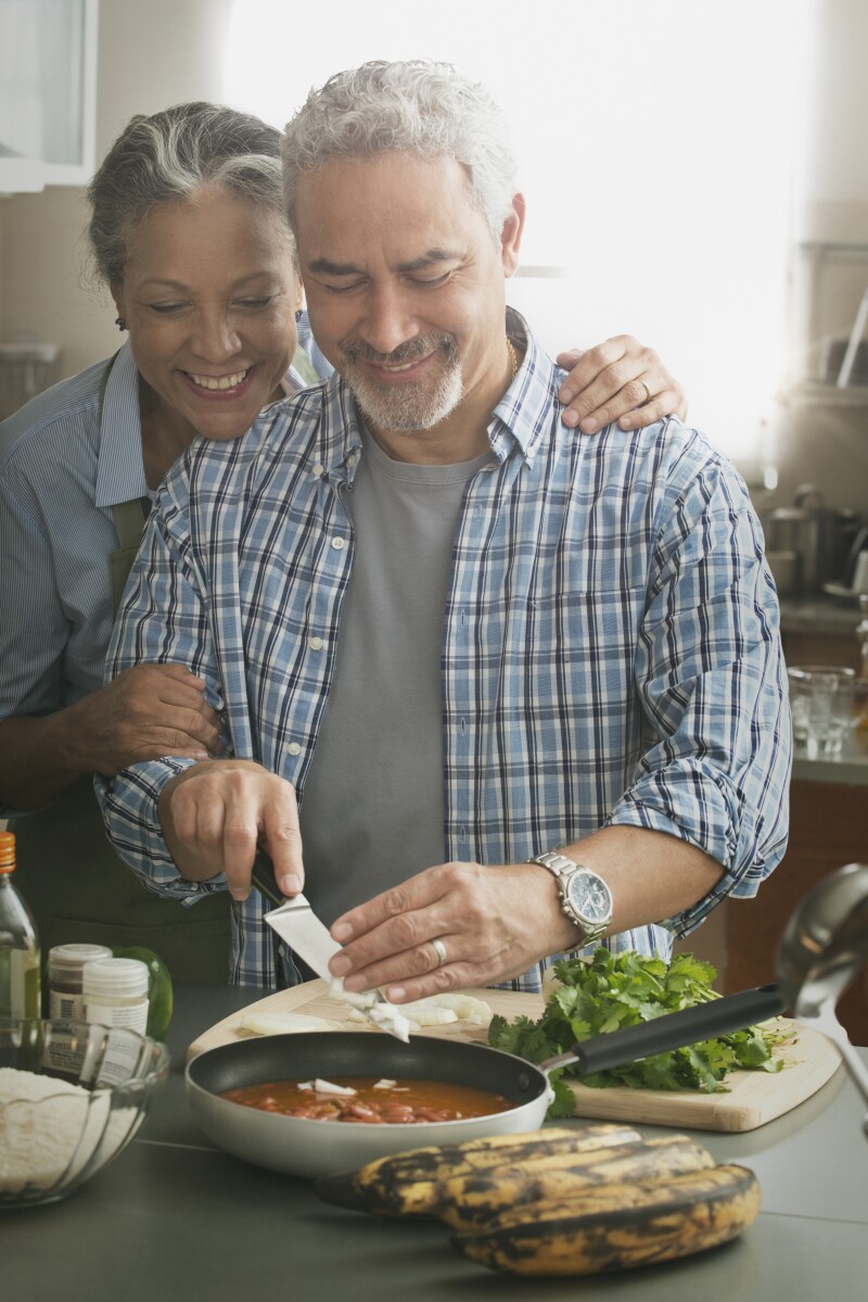 Hispanic couple cooking in kitchen