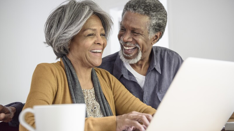 Senior African American couple using laptop and laughing