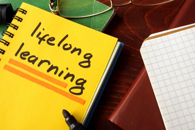 Notebook with lifelong learning sign on a table.