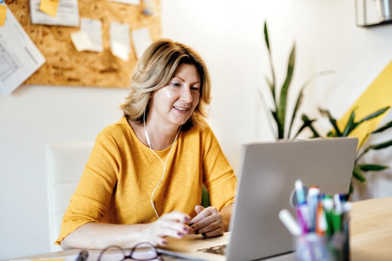 Mature businesswoman working from home and attending video conference meeting