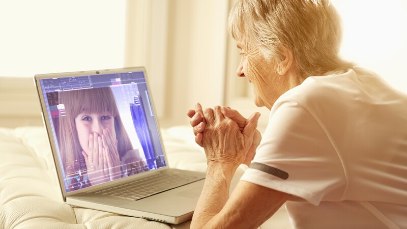 Older Caucasian woman video-chatting with granddaughter
