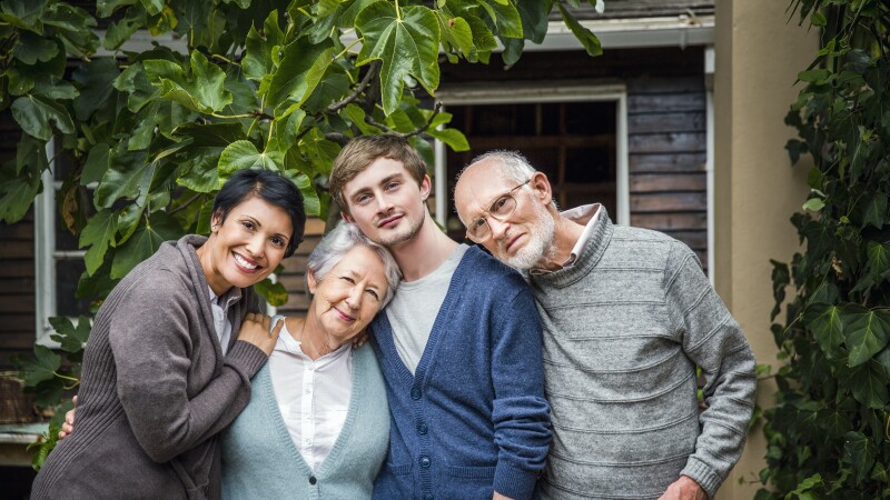 Multi-generation family standing together in yard