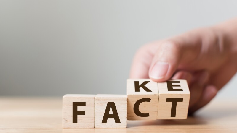 Fact or Fake concept, Hand flip wood cube change the word, April fools day