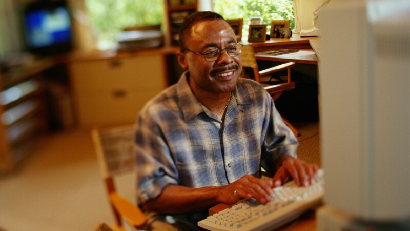 MAN ON COMPUTER AT HOME, AFRICAN AMERICAN