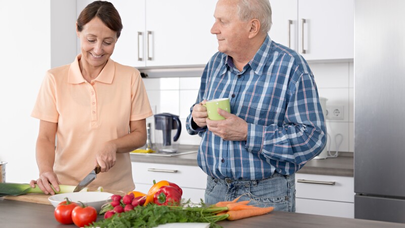 Home caregiver with senior man in a kitchen