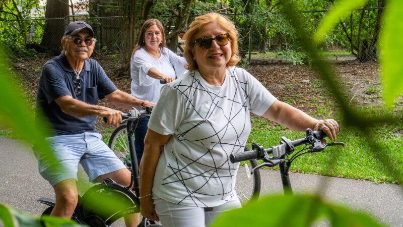 An older man and two women on bikes