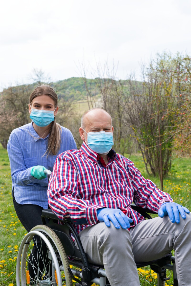 Assisted elderly man sitting in wheelchair