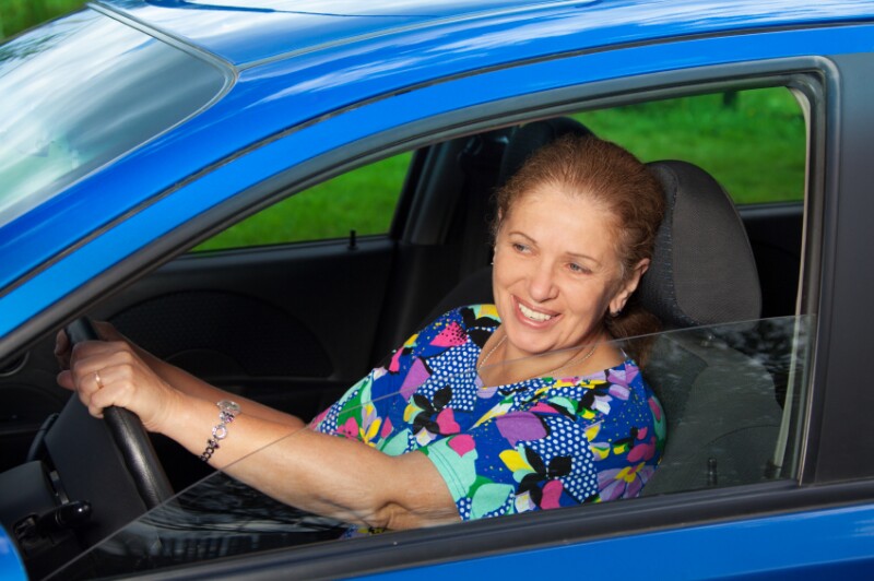 cheerful senior woman driving