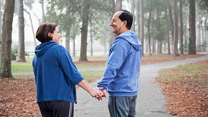 Hispanic couple walking in park