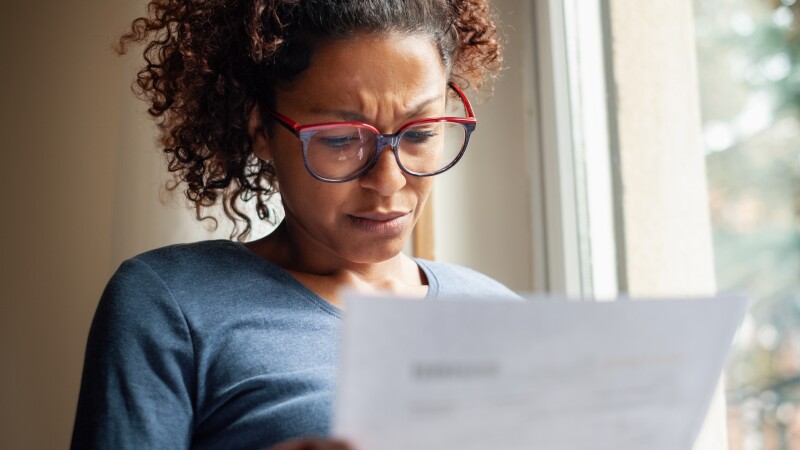 Woman near window reading bad news letter