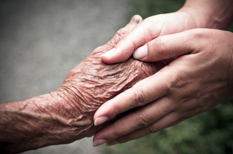 Senior and young holding hands