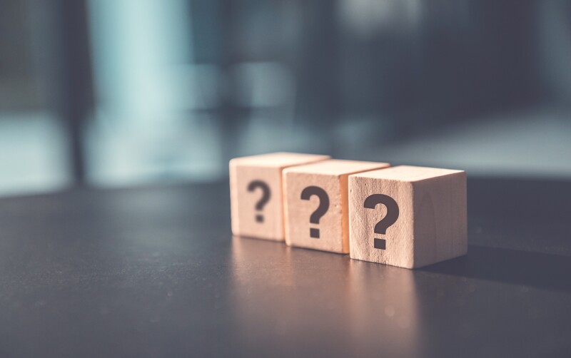? Questions Mark word in wooden cube block on table background. FAQ Answer, Q&A.