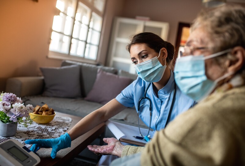 Doctor measuring blood pressure during home visit.