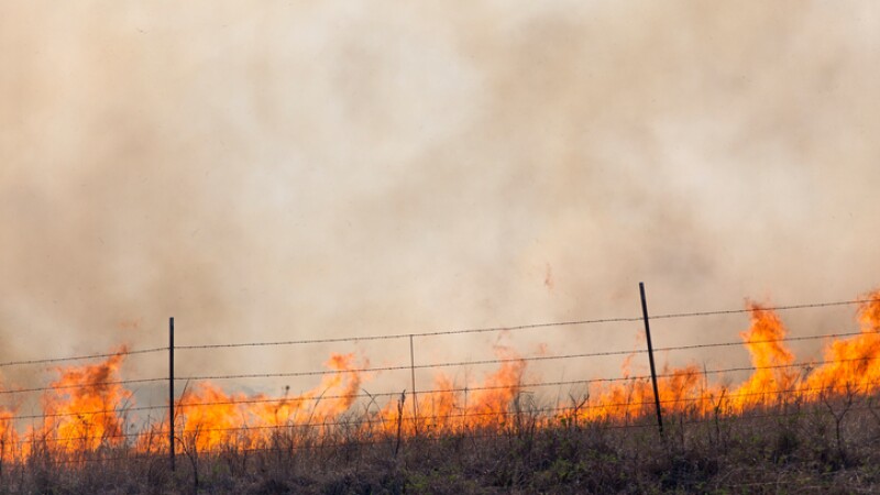 prairie fire and barbed wire fence