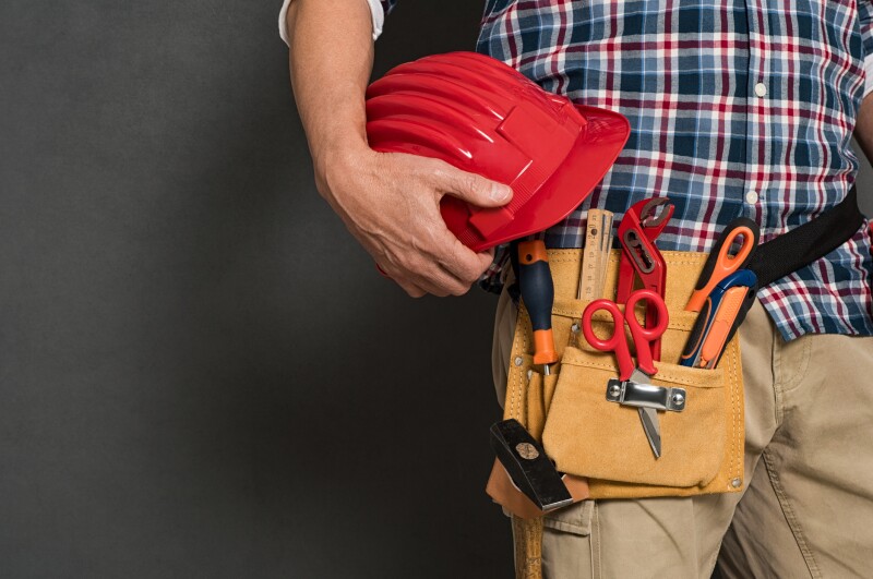 Worker holding hardhat and toolkit