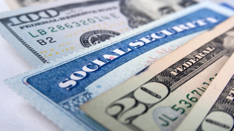 Social Security Card in front of Benjamin Franklin on dollar note